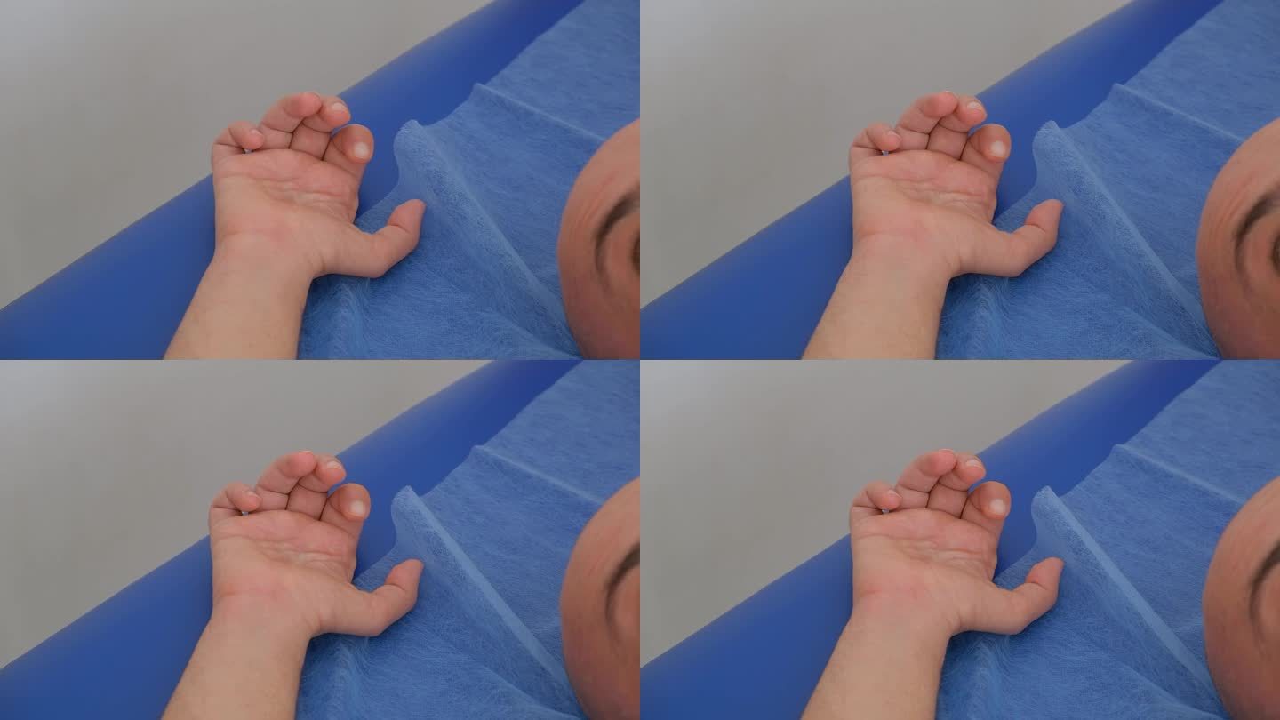 在肌肉刺激过程中，男性患者的手的特写。