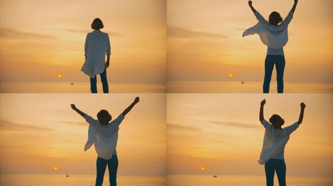 在克罗地亚罗维尼，日落时分，一名无忧无虑的女游客站在海边，双手高举，映照着广阔的橙色天空
