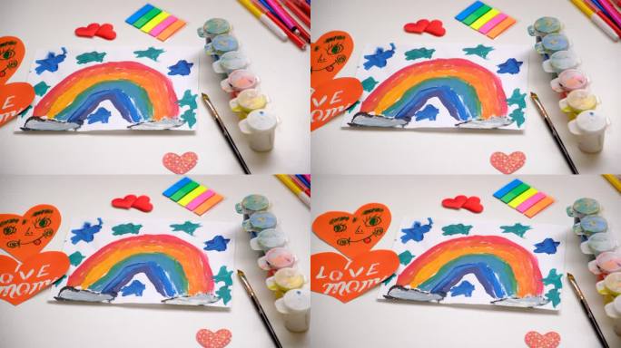 儿童女孩画彩虹，贺卡，心，礼物的母亲节，生日或情人节。工艺美术概念。顶视图表