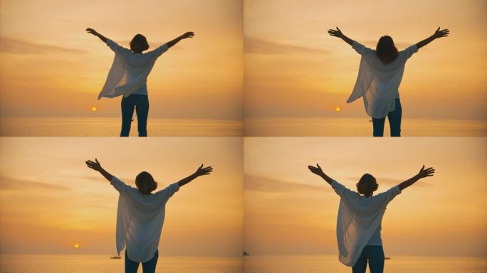 在克罗地亚罗维尼的夕阳下，一名无忧无虑的女游客站在海边，张开双臂，面对着广阔的橙色天空