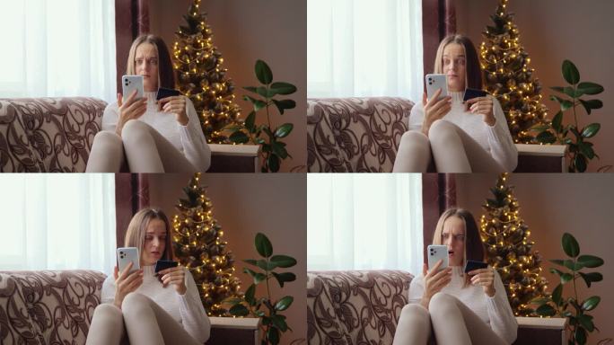 一位棕发女子坐在圣诞树旁的沙发上，用手机输入信用卡支付信息，却发现自己的虚拟钱包里没钱了。
