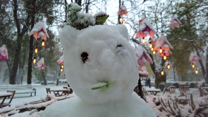 近距离拍摄公园里的雪人，冬天下着大雪