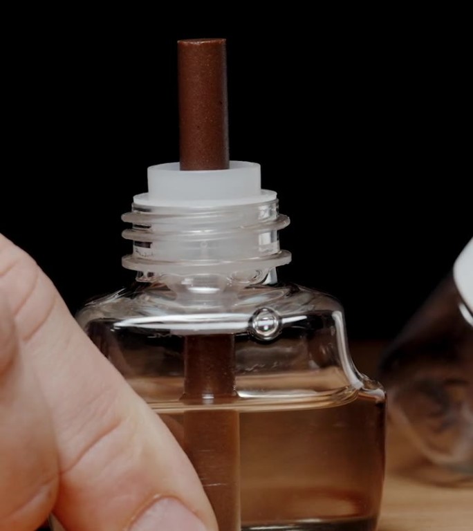 垂直视频。拧开瓶盖，是一瓶液体驱虫剂。