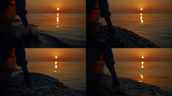 优雅的飞溅:黄昏航行时，一个女人的手抚摸着水面