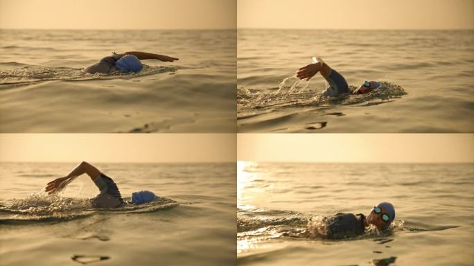 日落时，坚定的中年成年女子在海景中对着天空游泳的锁定镜头。女游泳运动员在阳光下在海上游泳