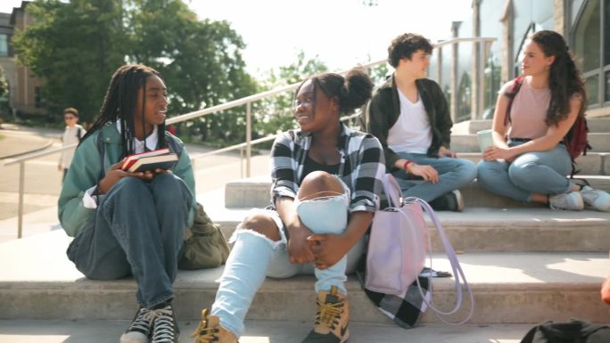 一群大学生坐在教学大楼的台阶上