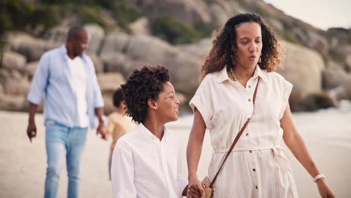 散步，幸福的家庭在海滩上一起聊天，在热带探险假期。谈话中，暑假和妈妈、爸爸和孩子在海边放松，微笑着牵