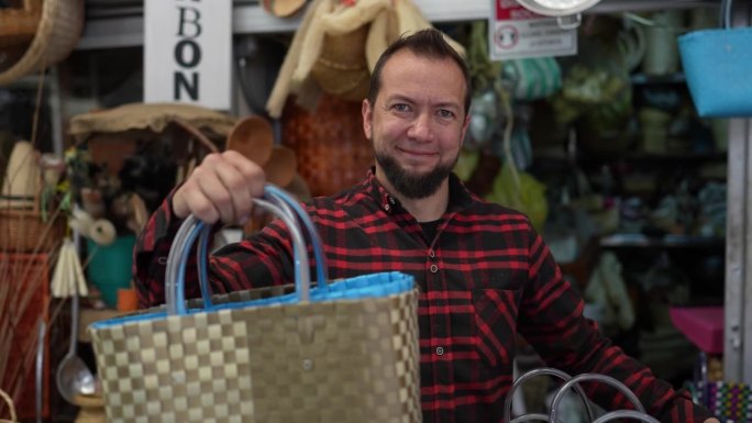 一个成熟的男人在商店里拿着柳条篮子的画像
