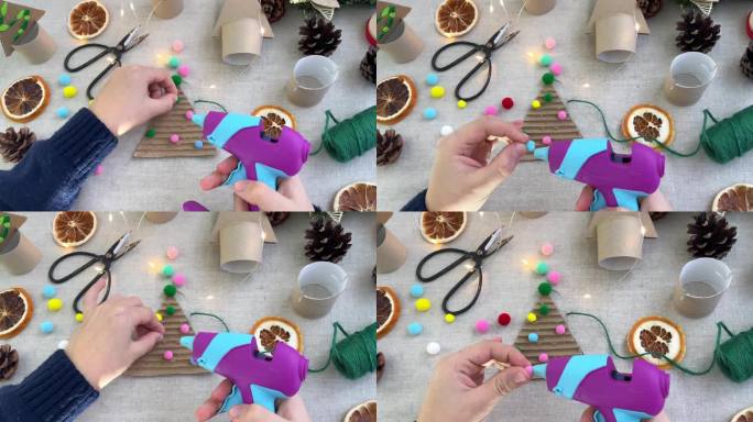 手工圣诞树装饰。孩子们的手用彩色球装饰纸板做成的圣诞树的特写。零废物概念。