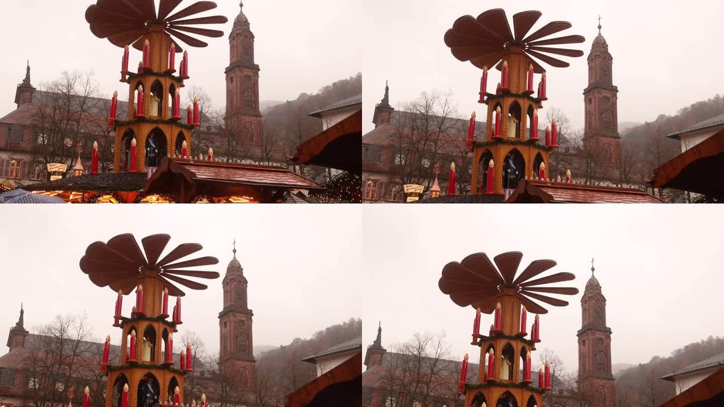 在欧洲的一个圣诞集市上，德国海德堡一座教堂尖顶前的木制金字塔旋转螺旋桨