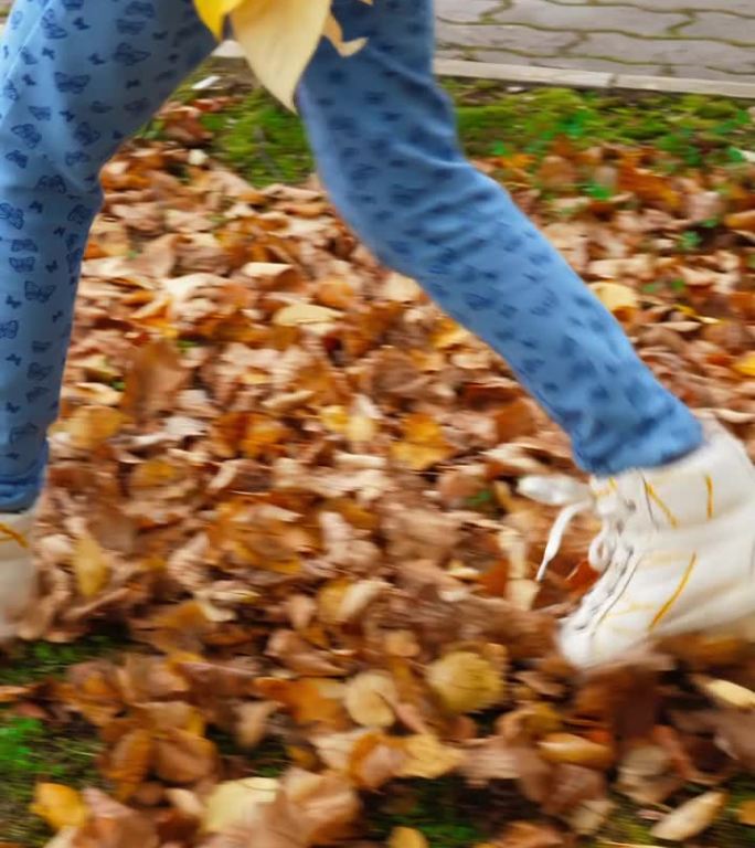 穿着白鞋的年轻女孩走在枯黄的秋叶上
