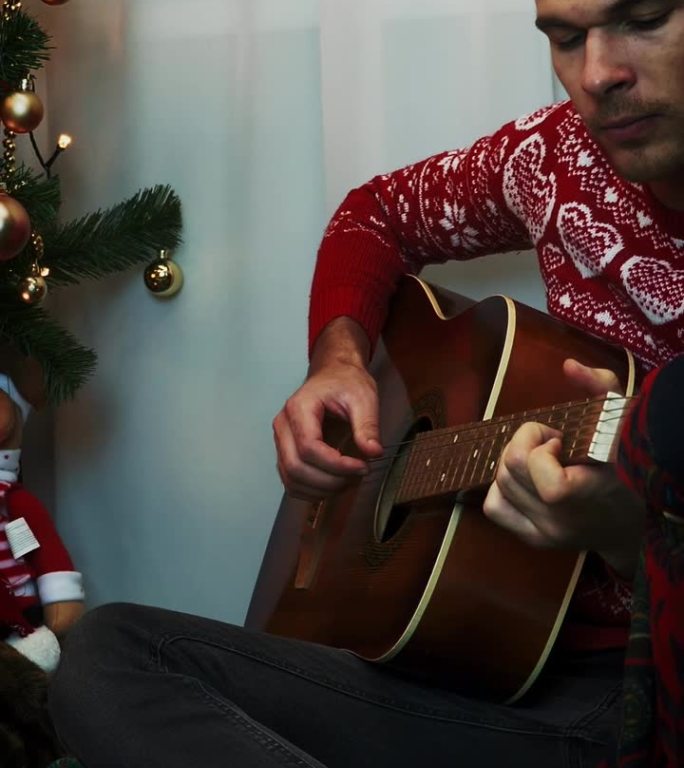 节日的人在新年弹着吉他，唱着圣诞歌。垂直视频