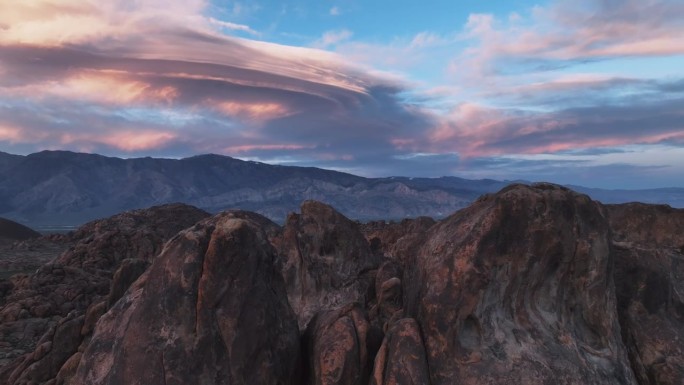 最美丽的粉红色透镜状云和一只孤独的鸟飞过阿拉巴马山的岩石场景。