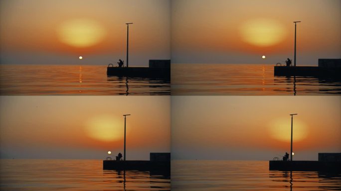 宁静的渔村:一个渔夫在码头的剪影，在夕阳下捕鱼