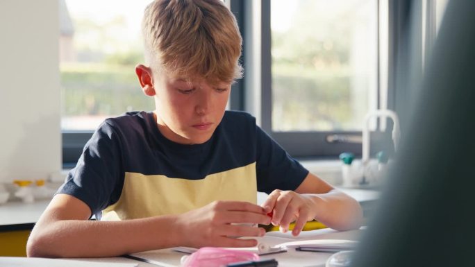 男中学生在科学课上建立原子或分子模型