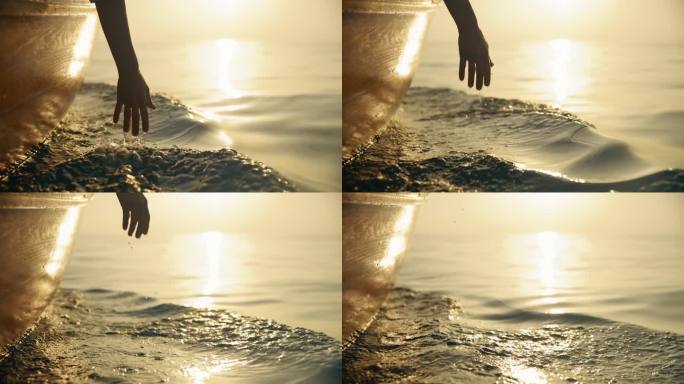 SLO莫优雅的飞溅:一个女人的手溅水，而在日落航行