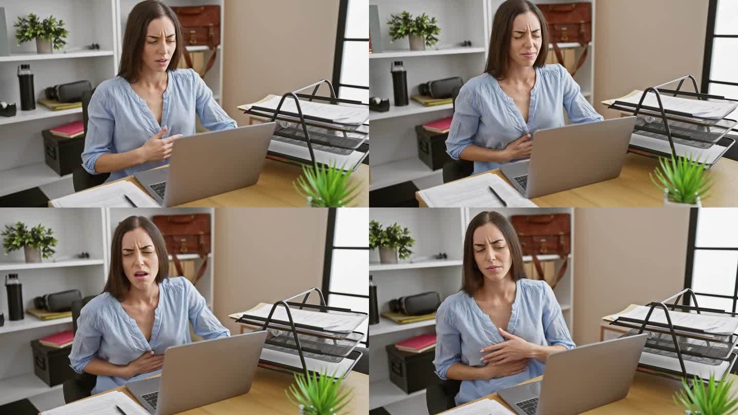 年轻漂亮的西班牙女性在办公桌前用笔记本电脑工作时胃痛