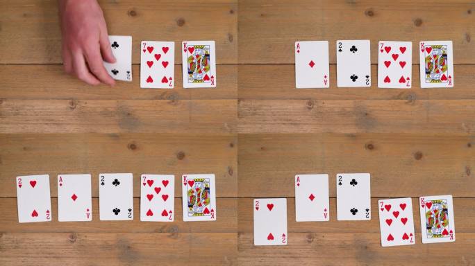 牌手:一个人在木桌上摆出红心同花来教观众如何打扑克