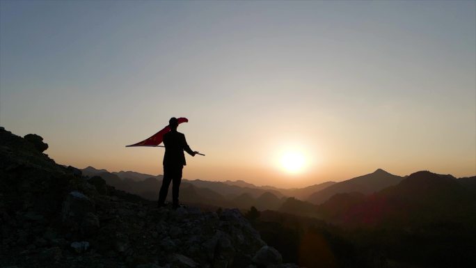 拿着红旗山顶挥舞国旗飘扬爱国教育人物背影