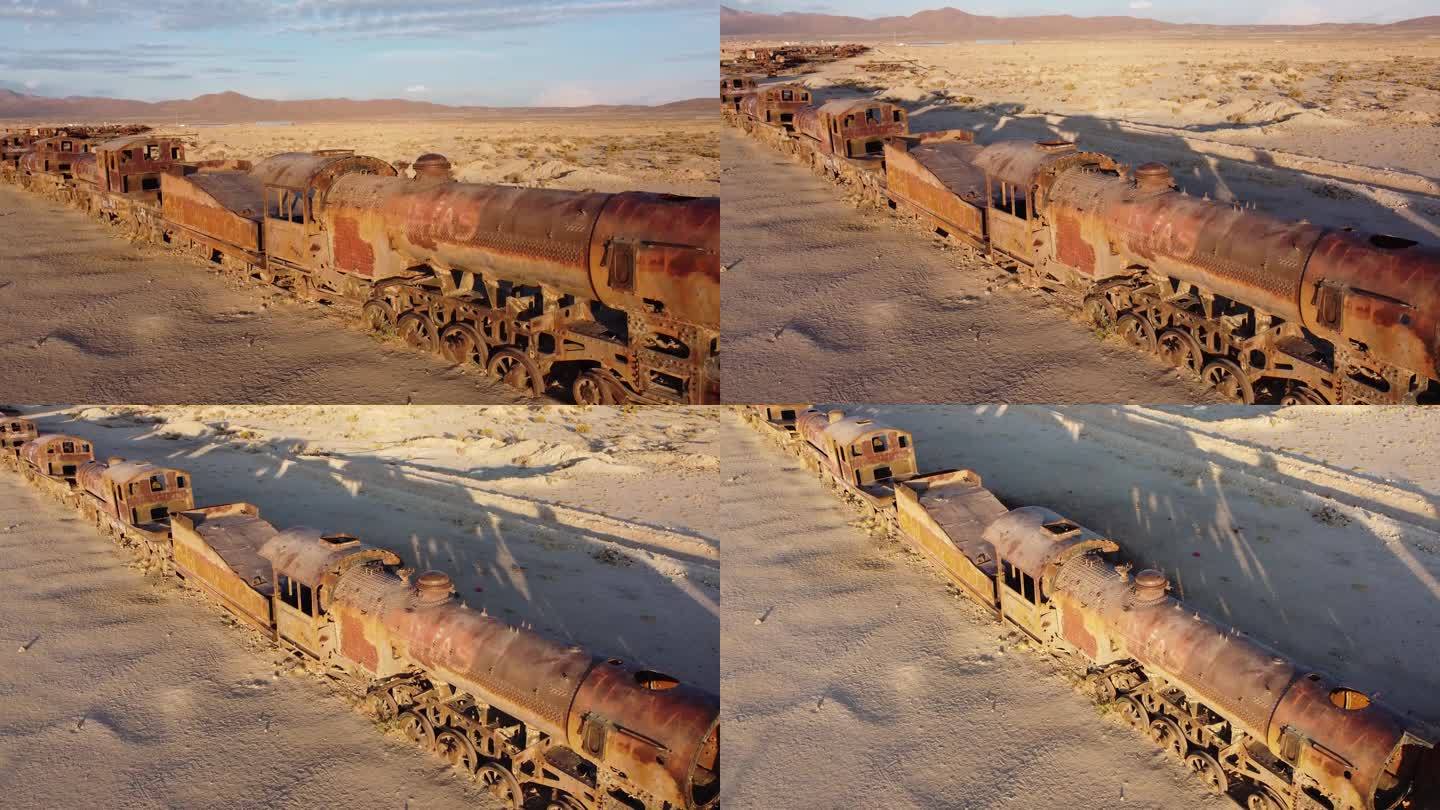 在沙漠风景中，摄像机在一辆生锈的蒸汽机车前升起