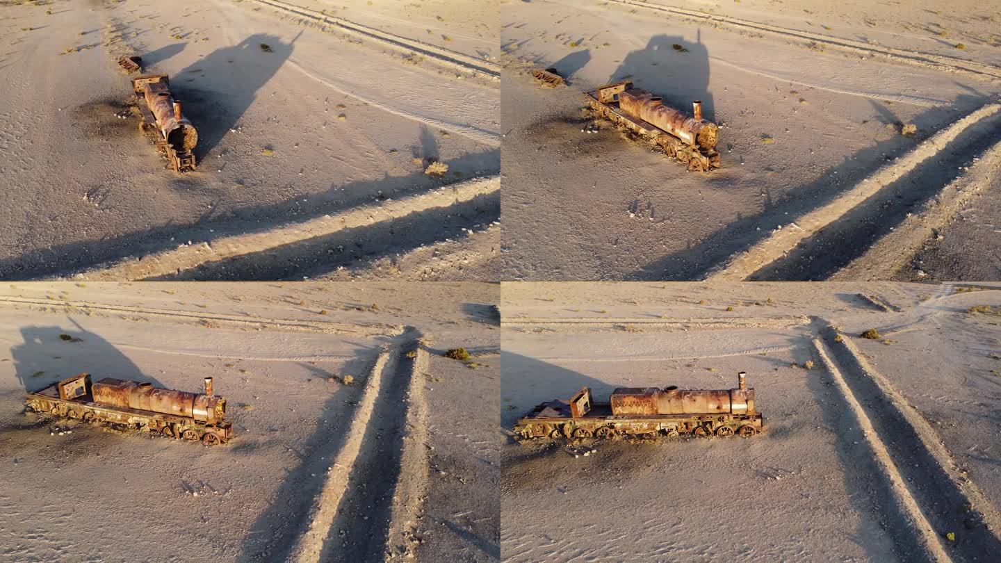 镜头慢慢地围绕着一辆孤零零的、被遗弃的、生锈的蒸汽机车，它矗立在一片沙漠之中