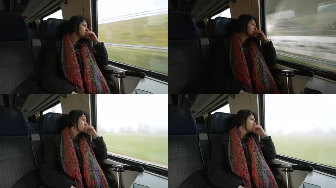 坐火车旅行的沉思的女人凝视着欧洲高铁里路过的风景。秋天，乘客戴着围巾在上下班路上做白日梦