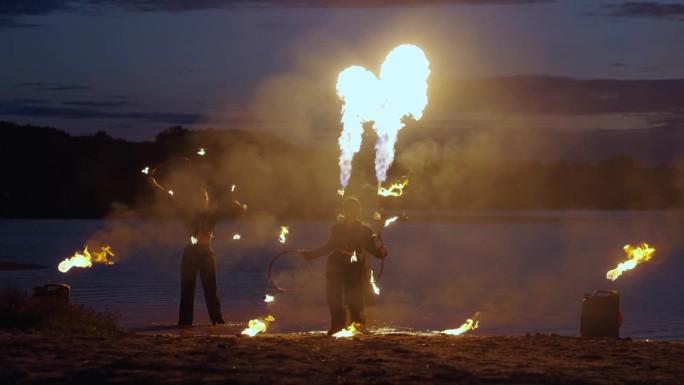 夏夜，马戏艺人在河滨表演火焰表演，用火焰表演惊人的戏法