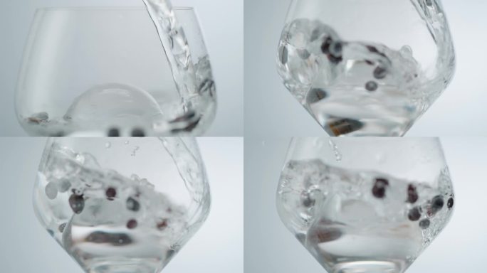 水倒在圆冰块和浆果在葡萄酒杯