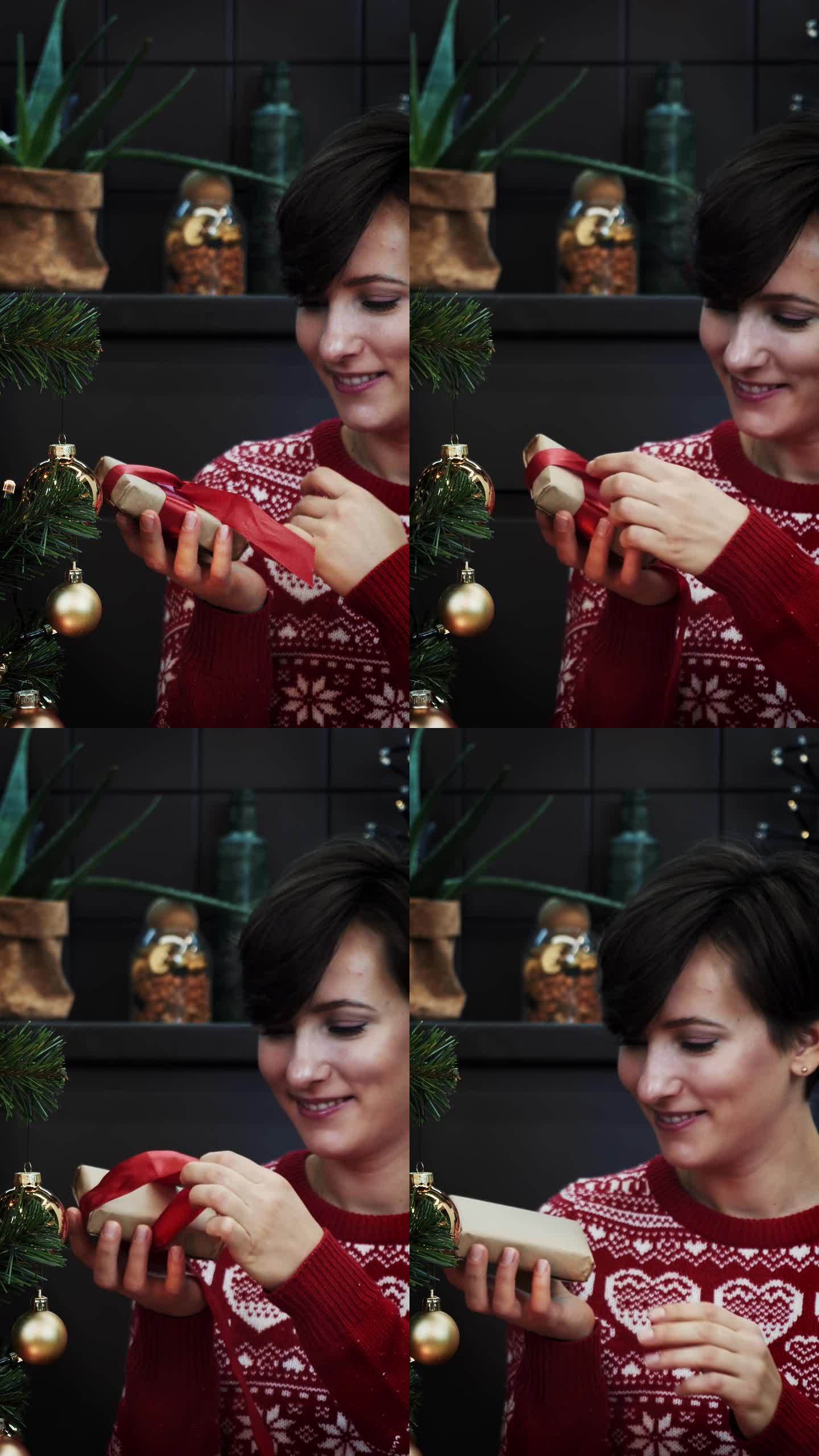 一位女士正在打开系着红丝带的精心制作的礼盒。新年。垂直视频