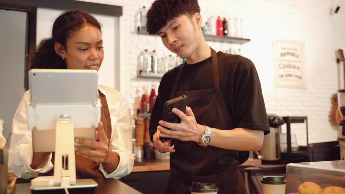 收银员或咖啡师正在通过电话从客户订购应用程序中接受订单。销售点系统，客户服务和小型企业解决方案。