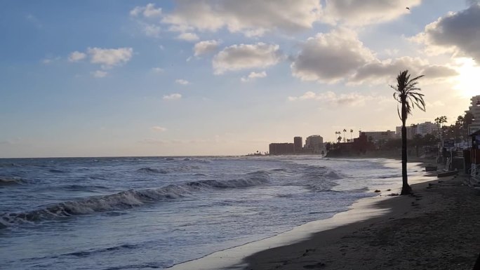在一个寒冷的冬日，西班牙太阳海岸的贝纳尔马德纳海滩上，海浪拍打着海滩的短视频。