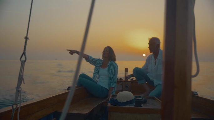 航行到日落的幸福:一对幸福的夫妇在一艘帆船的甲板上放松