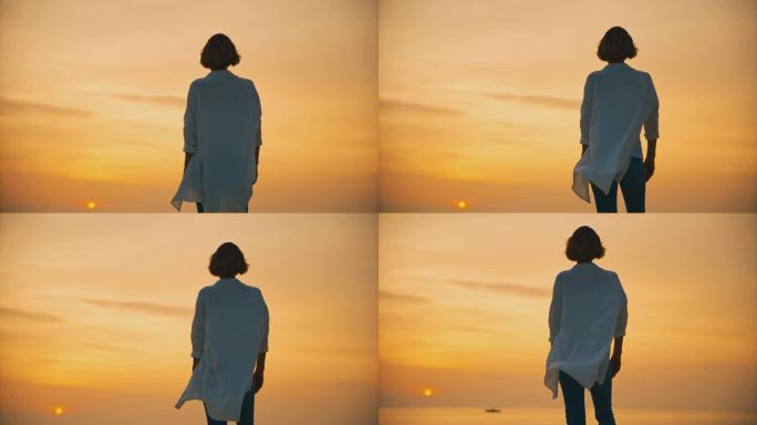 欣赏日落的女人。克罗地亚罗维尼，日落时分，女游客站在大海上广阔的橙色天空的后视图