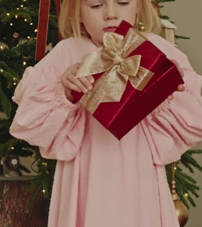 帮助的概念，捐赠。可爱的小女孩打开一个空的礼品盒。