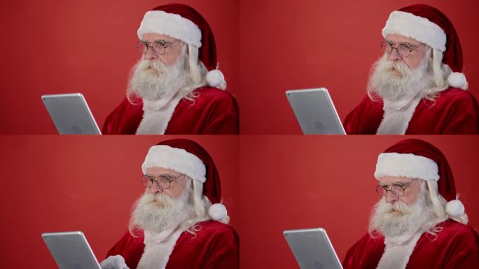快乐的圣诞老人在平板电脑上阅读愿望清单