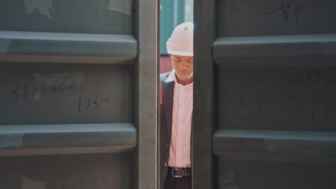 非裔美国工程师工人在集装箱码头打开集装箱