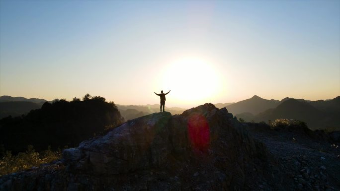 大气人物背影一个人站在山顶张开双臂攀登者