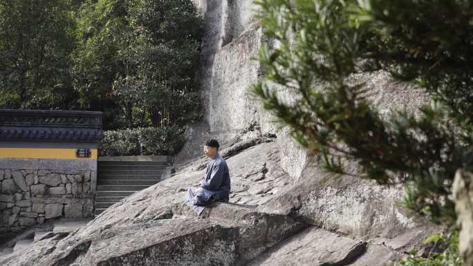 寺庙户外岩石上打坐的僧人和尚