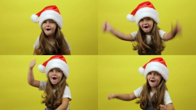 蹦蹦跳跳的小女孩戴着圣诞老人的帽子，在黄色的背景工作室里跳舞，玩得很开心，有表现力的手势。新年快乐的