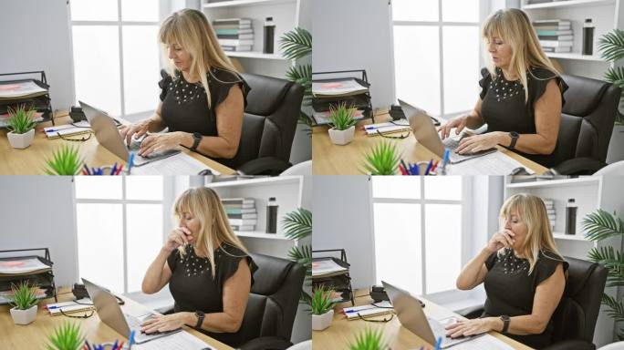 美丽的中年金发女子，专业的商务工作者，在办公桌旁对着笔记本电脑紧张地工作，咳嗽——这是一种令人担忧的