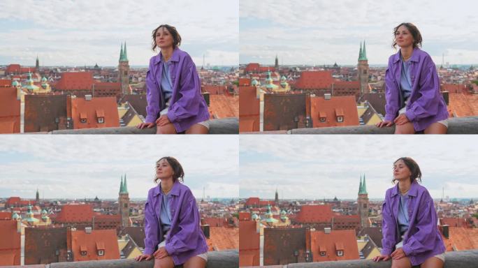 一个女人坐在屋顶上，看着纽伦堡的城市景观