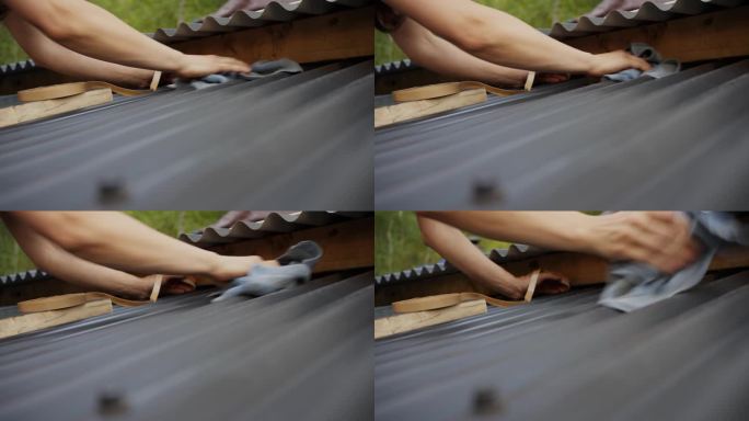 一名妇女正在给甲板上的波纹屋顶板涂胶条