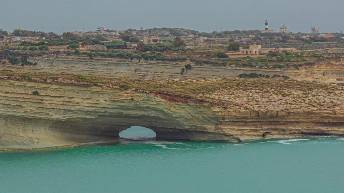 延时拍摄了马耳他海岸Hofriet窗口岩石拱门前的水流运动