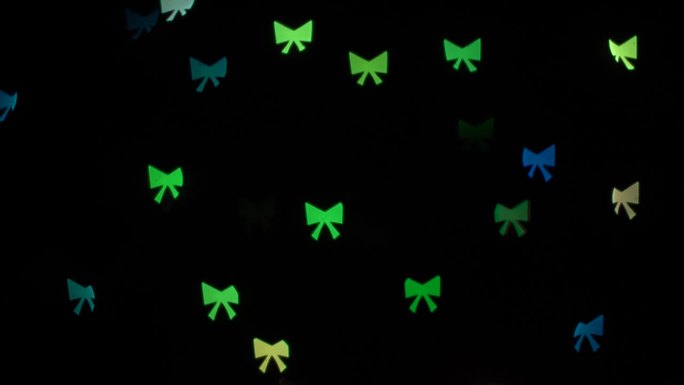 闪烁的散景灯蝴蝶结在黑色背景的装饰花环。