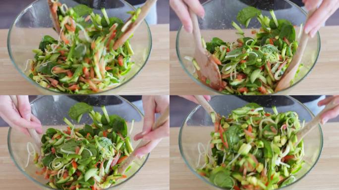 一个女人用两个木勺在碗里拌沙拉的特写镜头。一碗沙拉。美味的素食沙拉。健康的绿色午餐。