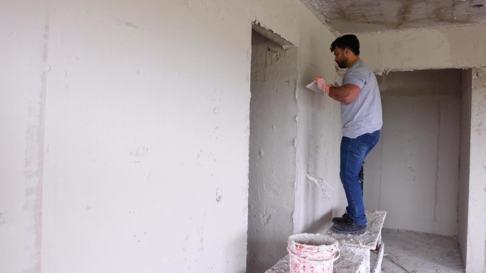拉丁美洲的建筑工人在建筑工地给墙壁抹灰泥