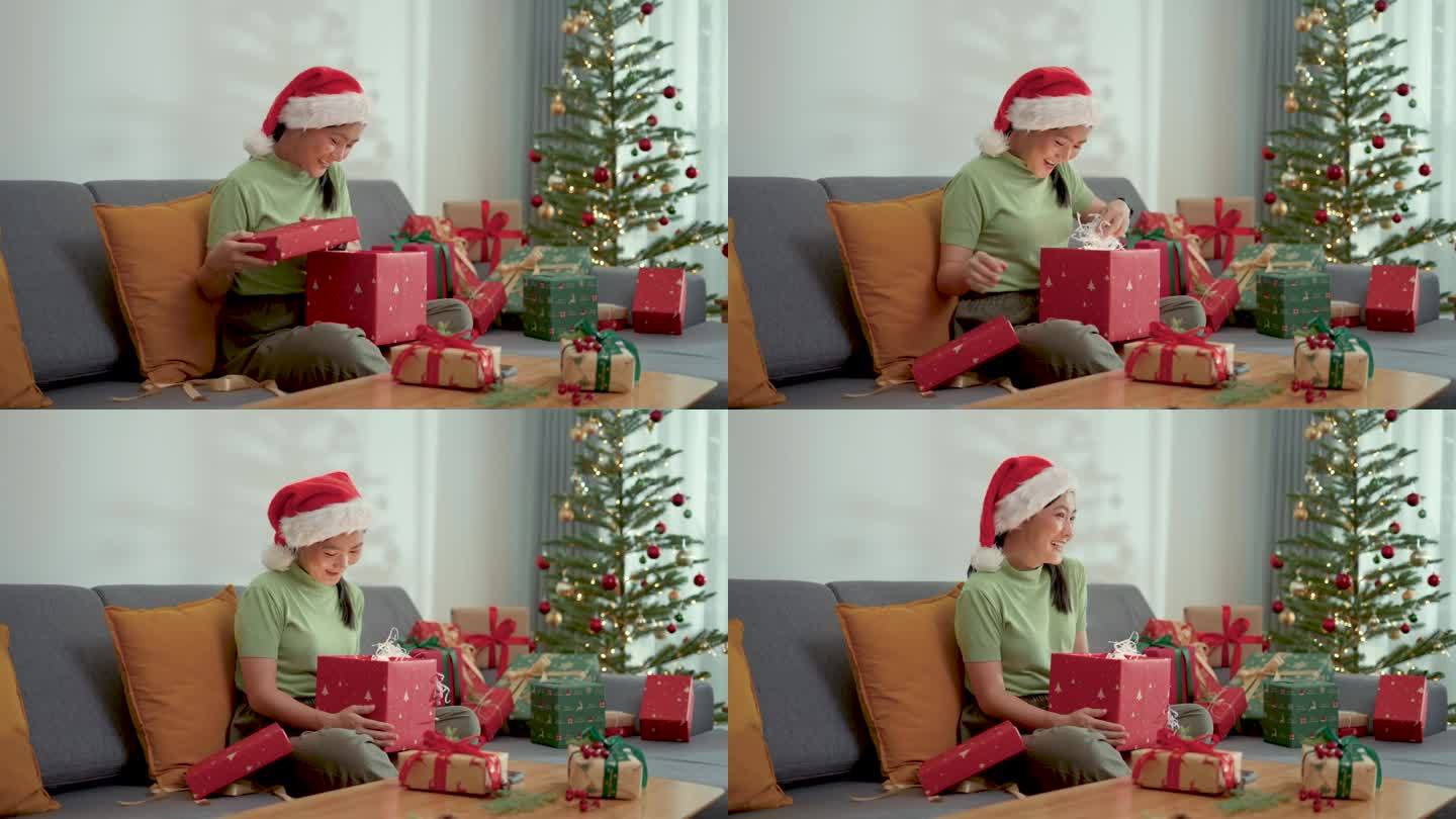 一名亚洲女子在圣诞节打开礼盒时惊喜不已。