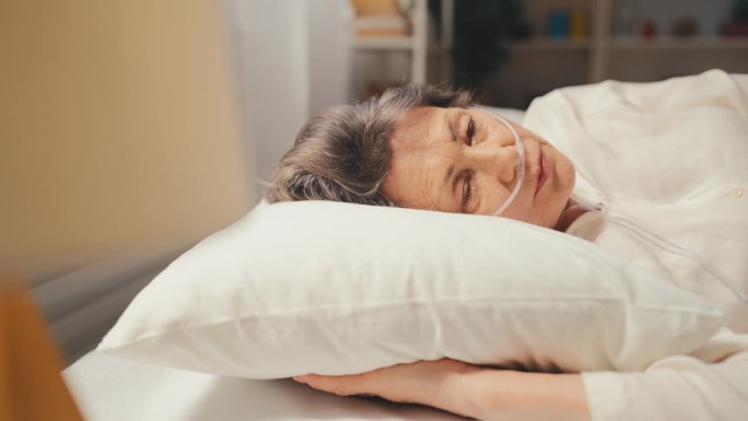患病的老年妇女躺在床上，患阻塞性肺病，年事已高