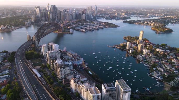在一个阳光明媚的清晨，航拍无人机俯瞰悉尼市、悉尼港和海港大桥，俯瞰新南威尔士州的拉文德湾