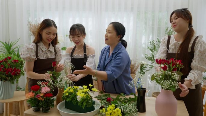 一名中年女教师逢年过节在家给三个小女孩教插花，赚取外快。